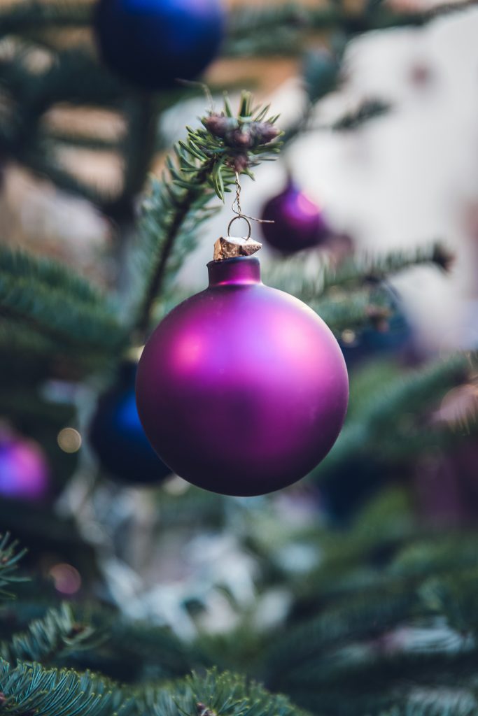 Purple bauble hanging on a Christmas tree